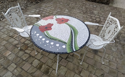 Table en mosaïque motif coquelicots réalisée avec un mélange de matériaux